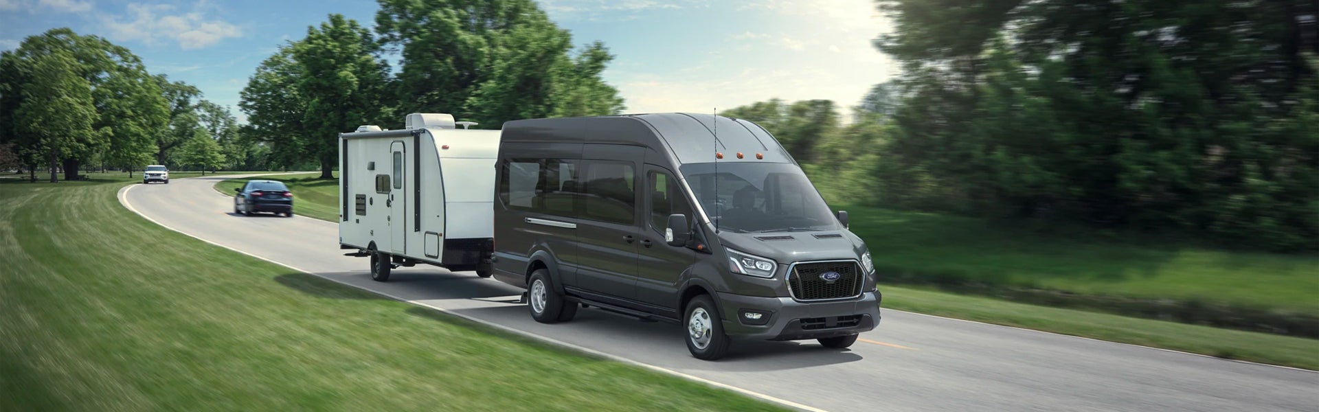 A Ford Transit Van hauls a camper.